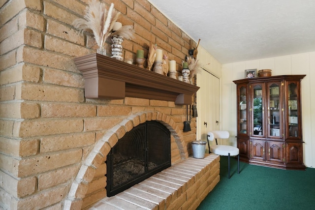 interior space featuring a fireplace, carpet floors, and a textured ceiling