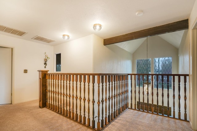 hallway with light carpet and lofted ceiling with beams