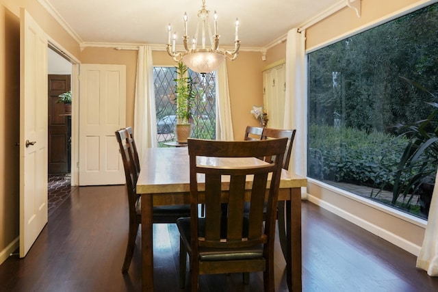 dining area with dark wood-type flooring, a notable chandelier, and ornamental molding