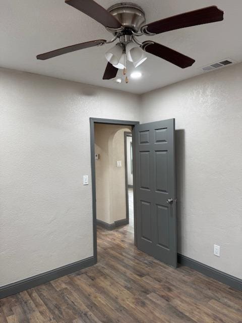 empty room featuring ceiling fan and dark hardwood / wood-style floors