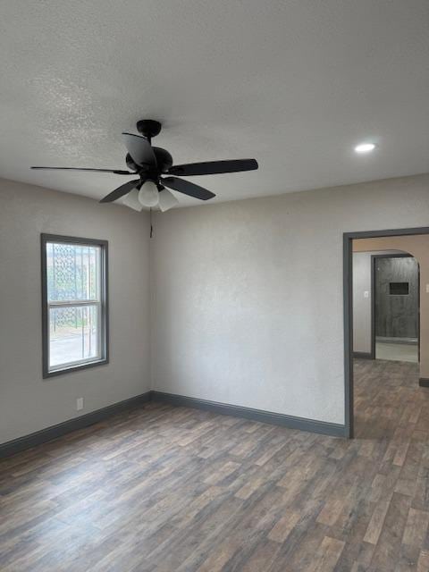 unfurnished room featuring a textured ceiling, ceiling fan, and dark hardwood / wood-style floors