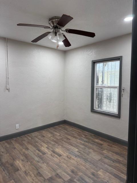 spare room featuring ceiling fan and dark wood-type flooring