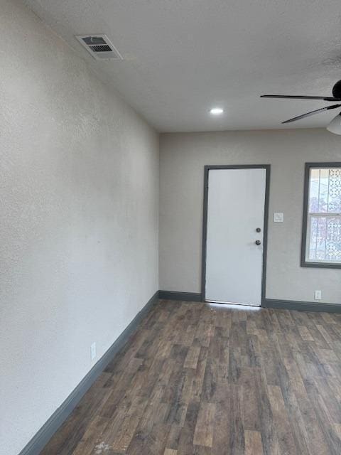 unfurnished room with ceiling fan and dark wood-type flooring