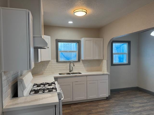 kitchen with white cabinets, plenty of natural light, sink, and white range with gas cooktop