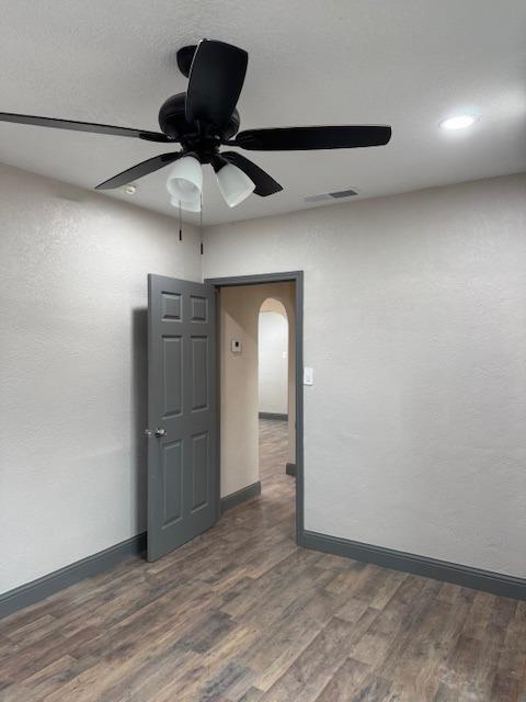 unfurnished room with dark hardwood / wood-style flooring and ceiling fan