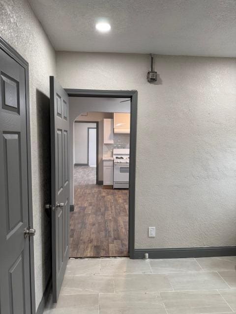 hall featuring hardwood / wood-style floors and a textured ceiling