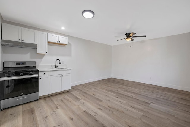 kitchen with white cabinetry, sink, ceiling fan, stainless steel range with gas stovetop, and light wood-type flooring