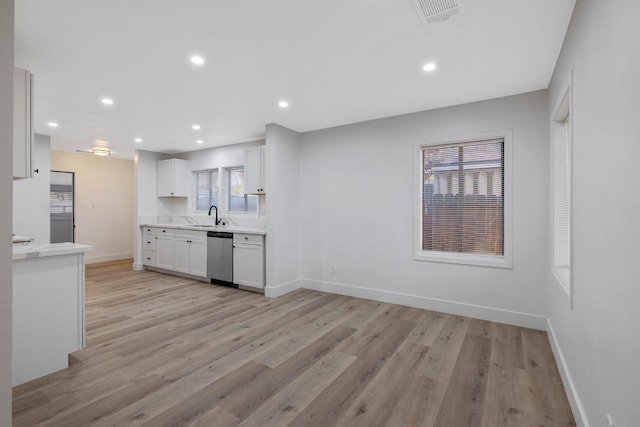 kitchen featuring dishwasher, light hardwood / wood-style flooring, white cabinetry, and sink