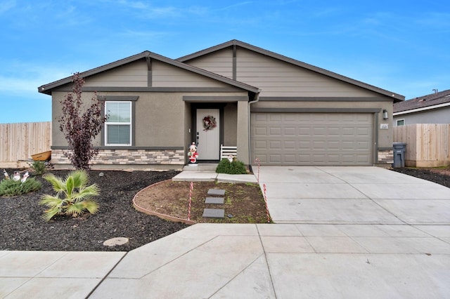 single story home featuring an attached garage, fence, stone siding, and driveway