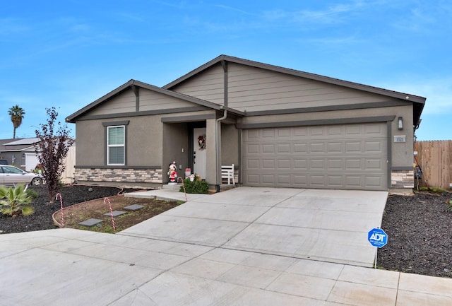 ranch-style house with concrete driveway, an attached garage, fence, and stone siding