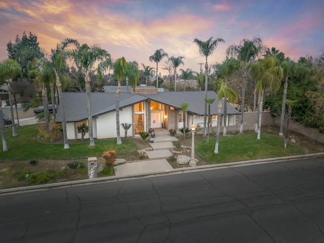 ranch-style house featuring a yard and a garage