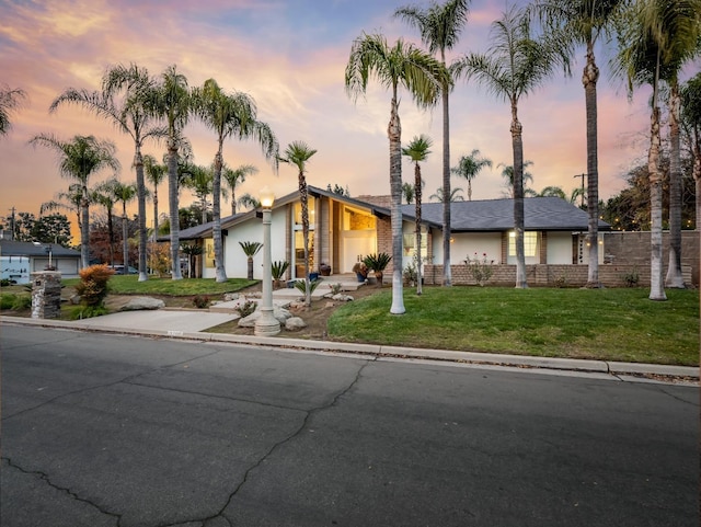 view of front facade featuring a lawn and a garage