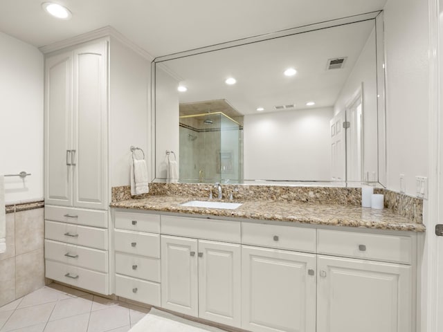 bathroom featuring tile patterned flooring, vanity, and a shower with door