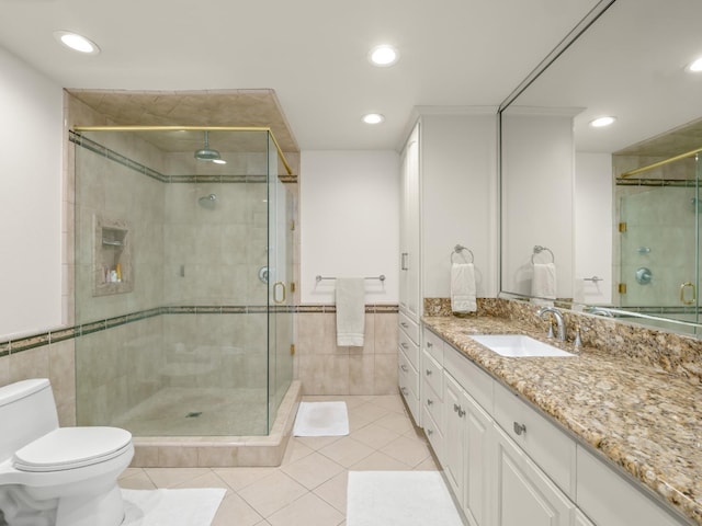 bathroom with tile patterned floors, vanity, toilet, and walk in shower