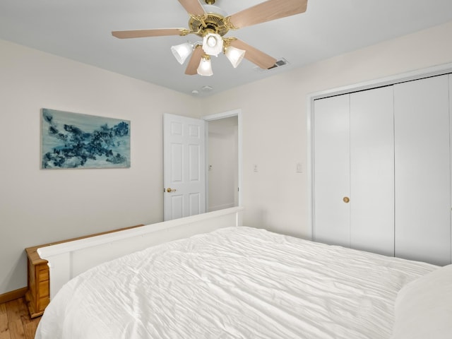 bedroom with ceiling fan, a closet, and hardwood / wood-style flooring