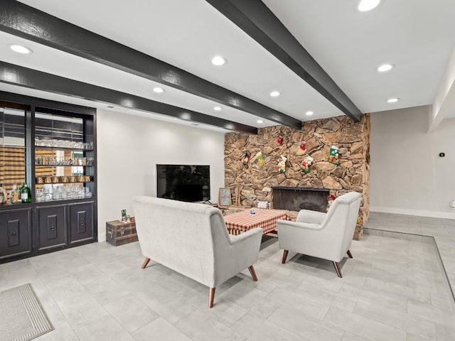 living room featuring a stone fireplace and beamed ceiling