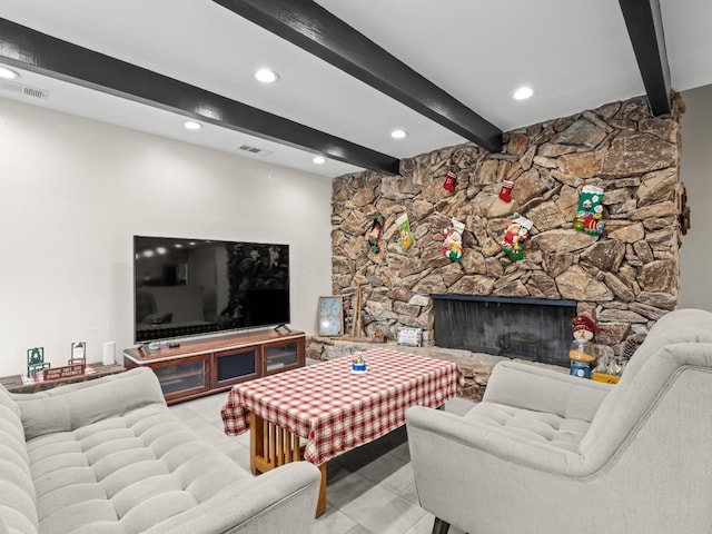 living room with beamed ceiling, a stone fireplace, and light tile patterned flooring