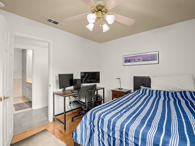 bedroom with ceiling fan, ensuite bathroom, and light hardwood / wood-style floors