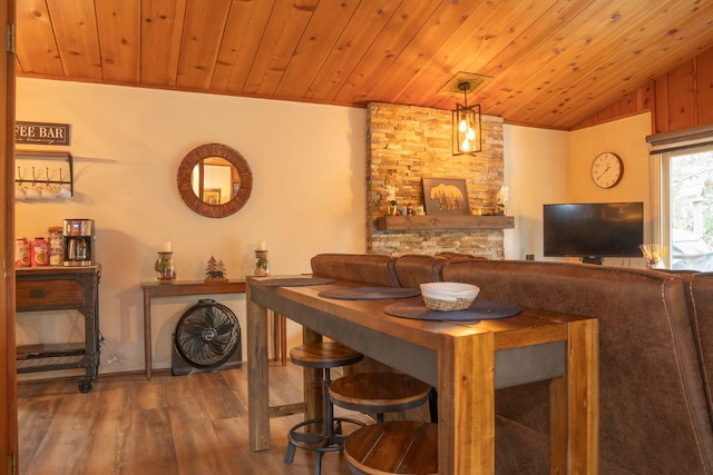 dining area with hardwood / wood-style floors, wood walls, lofted ceiling, and wood ceiling