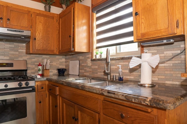 42135 Hanging Branch Rd, Shaver Lake, CA 93664 - kitchen featuring stainless steel range with gas cooktop, extractor fan, brown cabinets, tasteful backsplash, and dark stone counters