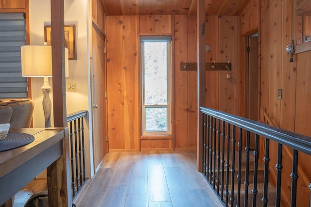 hall with hardwood / wood-style flooring, wood walls, and wood ceiling