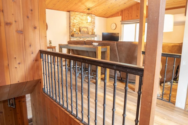 interior space with wood ceiling, wood walls, light hardwood / wood-style floors, and vaulted ceiling