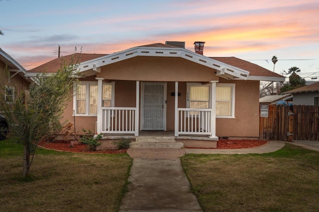 bungalow with a yard and a porch