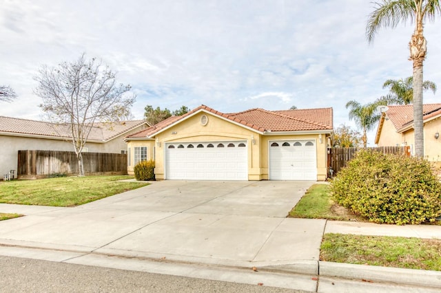 mediterranean / spanish-style home featuring a front yard and a garage