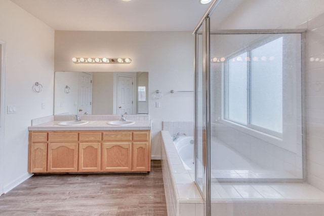 bathroom with wood-type flooring, vanity, and independent shower and bath