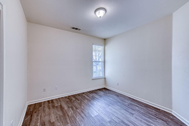 unfurnished room with dark hardwood / wood-style flooring