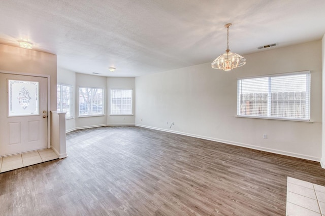 interior space featuring hardwood / wood-style floors, a chandelier, and a textured ceiling