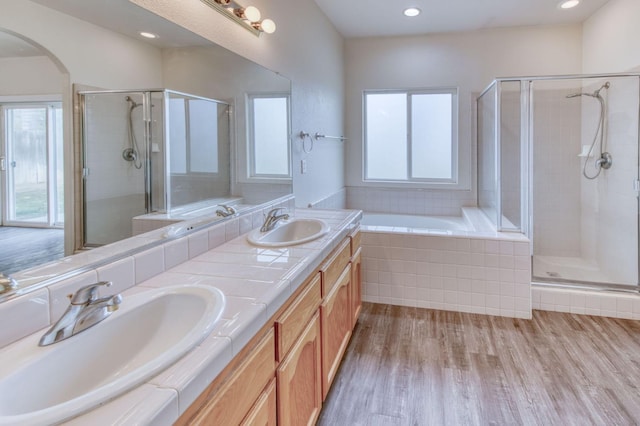 bathroom featuring hardwood / wood-style flooring, vanity, separate shower and tub, and a wealth of natural light