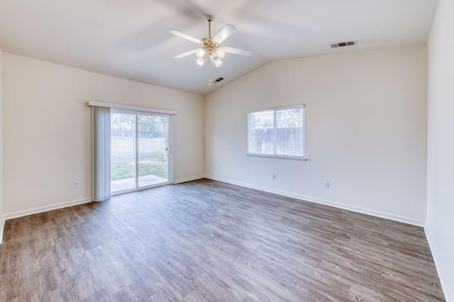 spare room featuring a wealth of natural light, wood-type flooring, and lofted ceiling