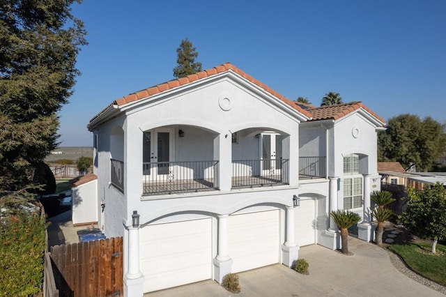 mediterranean / spanish home featuring a garage and a balcony