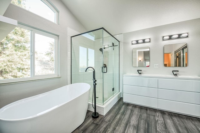 bathroom featuring wood-type flooring, shower with separate bathtub, vaulted ceiling, and vanity