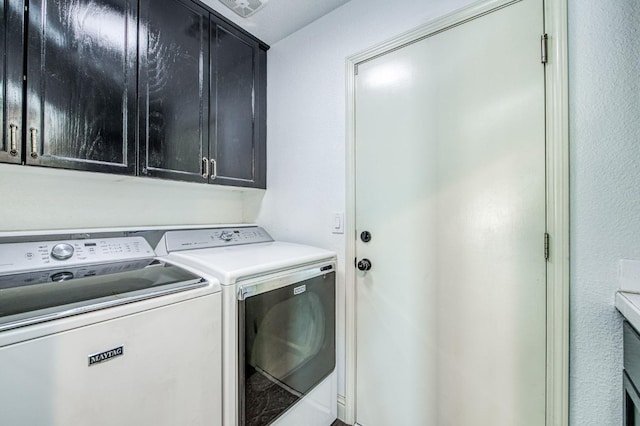 clothes washing area with cabinets and independent washer and dryer