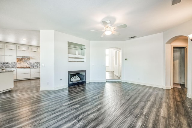 unfurnished living room with dark hardwood / wood-style floors and ceiling fan