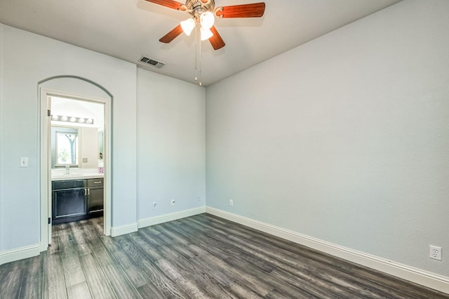 empty room featuring ceiling fan, sink, and dark hardwood / wood-style flooring