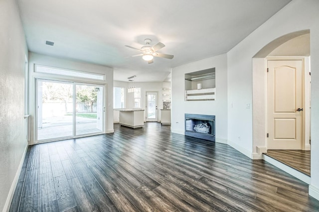 unfurnished living room with dark wood-type flooring and ceiling fan