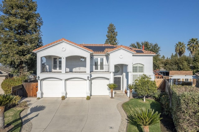 mediterranean / spanish house featuring a garage, a balcony, and solar panels