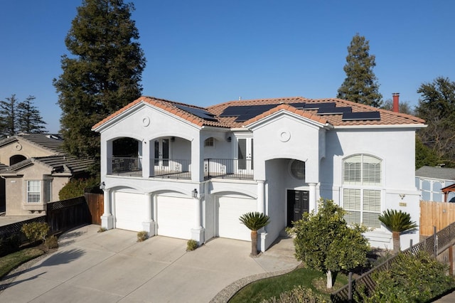 mediterranean / spanish-style home with a garage, a balcony, and solar panels