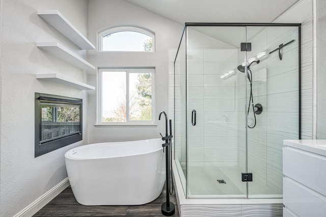 bathroom with hardwood / wood-style flooring, separate shower and tub, and a wealth of natural light