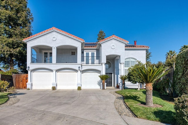 mediterranean / spanish-style home featuring solar panels, a front lawn, and a balcony