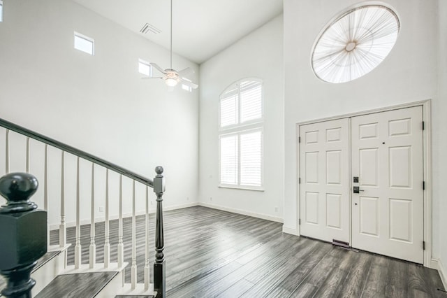 foyer with ceiling fan, a towering ceiling, and dark hardwood / wood-style floors