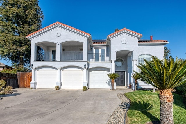 mediterranean / spanish home featuring a garage and a balcony