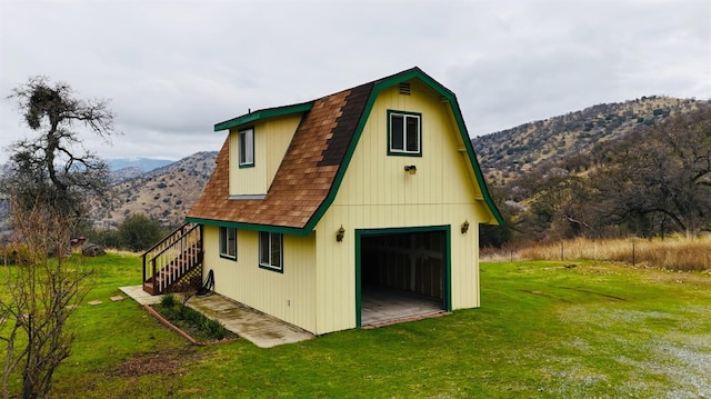 back of property with a lawn and a mountain view