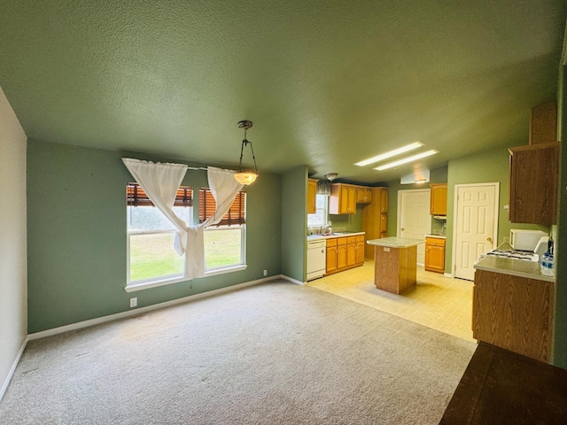 kitchen featuring light carpet, a textured ceiling, dishwasher, a center island, and hanging light fixtures