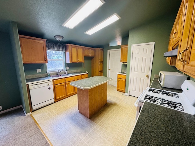 kitchen with lofted ceiling, white appliances, sink, a textured ceiling, and a kitchen island