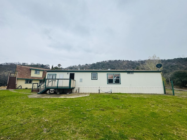 rear view of house featuring a lawn, a patio area, and a deck