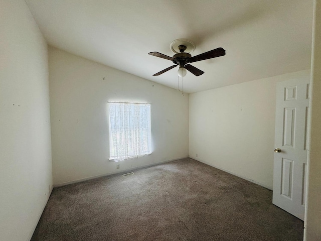 carpeted spare room featuring ceiling fan and vaulted ceiling